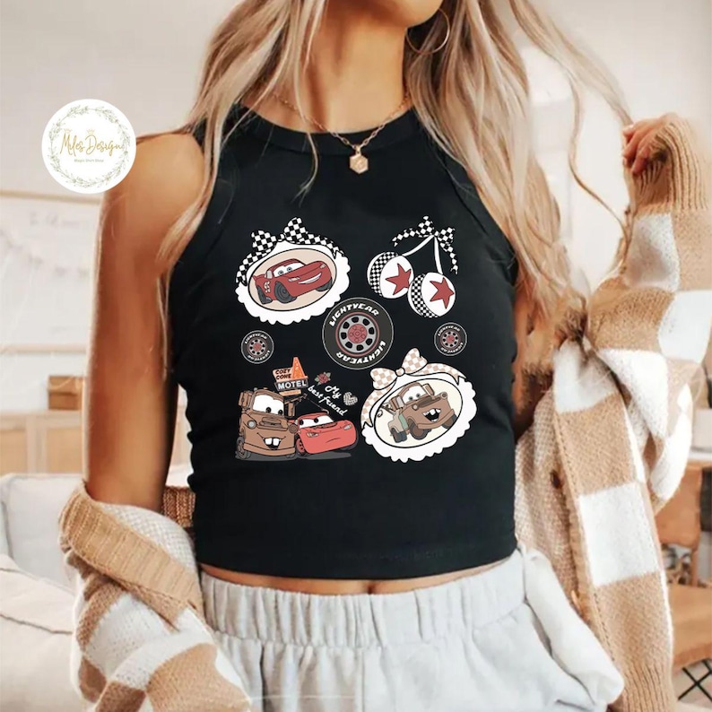 K&ouml;nnte beinhalten: Schwarzes Tanktop mit Cartoon-Autografiken. Das Design umfasst Bilder eines roten Rennwagens, eines braunen Lastwagens und eines Reifens mit dem Text "LIGHTYEAR". Der Text "My best friend" ist ebenfalls sichtbar. Das Tanktop ist &auml;rmellos.