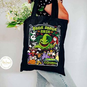 May include: Black tote bag featuring a colorful graphic of Disney characters, including Jack Skellington and Oogie Boogie. The text "Oogie Boogie Bash 20 Bash 25" is displayed above the characters, with "Disney California Adventure" below.