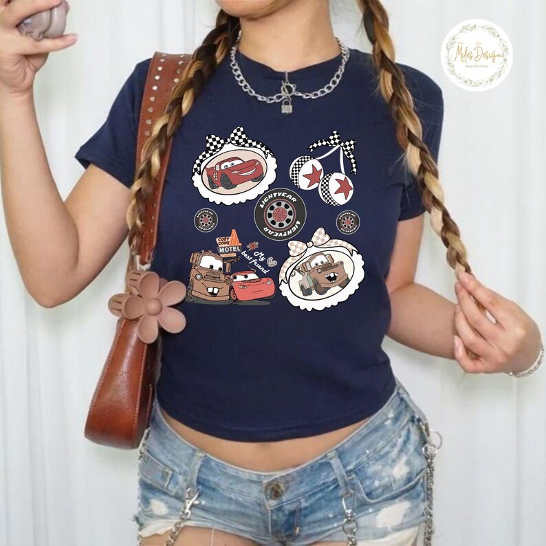 K&ouml;nnte beinhalten: Marineblaues T-Shirt mit Cartoon-Autografiken. Das Design umfasst Bilder von Lightning McQueen, Hook und anderen Charakteren mit dem Text "My best friend". Das Shirt hat einen runden Ausschnitt und kurze &Auml;rmel.