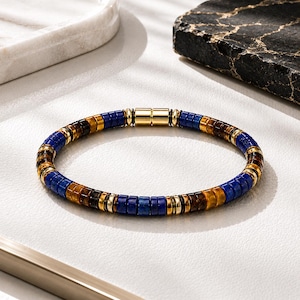 May include: A beaded bracelet featuring alternating segments of blue lapis lazuli and brown tiger eye disc beads, accented with small gold-toned metal spacers and a cylindrical gold-toned magnetic clasp closure, arranged in a circular pattern.