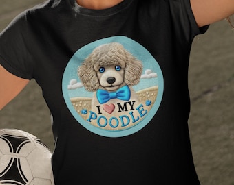 Könnte beinhalten: Ein schwarzes T-Shirt mit einem blauen Kreis-Motiv, das einen weißen Pudel mit einer blauen Schleife zeigt. Das Motiv enthält auch den Text "Ich liebe meinen Pudel" mit einem roten Herzen.