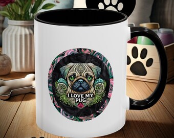Puede incluir: Taza de café de cerámica blanca con borde y asa negros. La taza presenta una ilustración colorida de un carlino con el texto "Me encanta mi carlino" en un círculo.