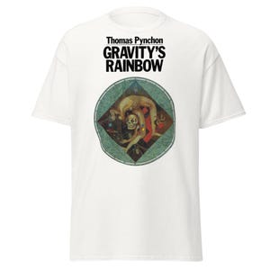 May include: White t-shirt featuring the text "Thomas Pynchon GRAVITY'S RAINBOW" in black. The shirt has a circular graphic with a figure in a contorted pose, with a skull and other figures.