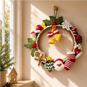 Puede incluir: Una corona circular marr&oacute;n decorada con varios adornos navide&ntilde;os de ganchillo, incluyendo un hombre de jengibre, una cara de Pap&aacute; Noel, un calcet&iacute;n a rayas, un peque&ntilde;o &aacute;rbol verde, campanas amarillas, manoplas rojas y hojas de acebo verdes.