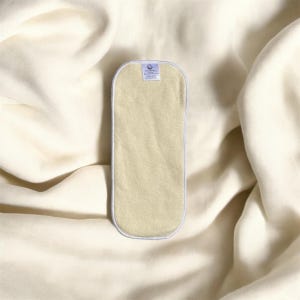 May include: A beige cloth diaper insert with a white border. The insert has a small white label with the text "Bamboo Charcoal Insert" printed on it.