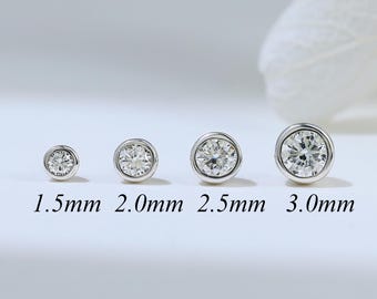 May include: Four silver-toned stud earrings with clear round stones in bezel settings, arranged in a row from smallest to largest. The sizes are labeled below each earring as 1.5mm, 2.0mm, 2.5mm, and 3.0mm, indicating the diameter of each piece.