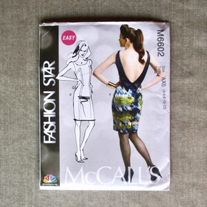 May include: A McCall's Fashion Star sewing pattern envelope. The front features a sketch and a photo of a woman wearing a backless dress with a floral print skirt. The envelope is labeled "Easy" and includes the pattern number M6602.