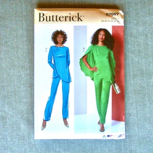 May include: A Butterick sewing pattern featuring illustrations of two women's outfits: a blue tunic and pants set, and a green cape top with matching pants. The pattern number B7009 is visible in the upper right corner.