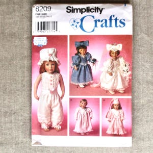 May include: A Simplicity Crafts sewing pattern featuring doll clothing designs. The pattern includes images of dolls in various outfits, including a dress, jumpsuit, and wedding dress. The pattern number is 8209.