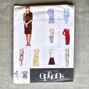May include: A vintage Vogue Easy Options sewing pattern. The cover features a woman in a burgundy dress and several illustrations of different outfit options. The pattern includes sizes 12-14-16.