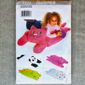 May include: A sewing pattern for making plush toys. The pattern includes instructions for making a cat, a panda, a crocodile, and a dalmatian. The pattern is from Butterick and the pattern number is 4224.