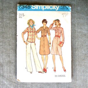May include: A Simplicity 7345 sewing pattern envelope for size 14, 36-inch bust. The cover features illustrations of three outfits: a plaid shirt with white trousers, a solid tan button-front dress, and a striped button-front dress with long sleeves.