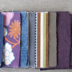 May include: A collection of fabric swatches in various colors and patterns, including denim, floral print, striped, and solid colors.