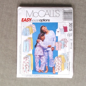 May include: A McCall's sewing pattern envelope, number 3015, size Z, featuring illustrations of various pajama sets and loungewear. The cover displays two individuals wearing light blue patterned pajamas against a blue background.