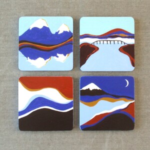 May include: Set of four square coasters with abstract landscape designs. Each coaster features a different scene with blue, white, red, brown, and gold colors.