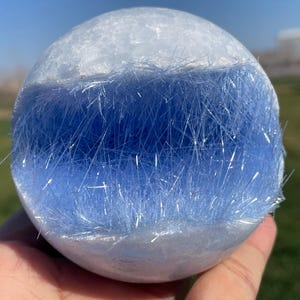 May include: A white sphere with a blue, crystal-like interior. The sphere is made of a translucent material and the crystals are visible through the sphere.