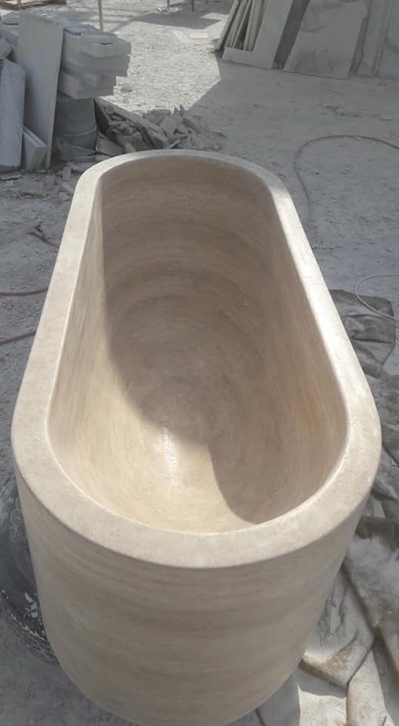 Puede incluir: Una ba&ntilde;era ovalada beige de piedra. La ba&ntilde;era tiene un interior liso y un exterior redondeado. El accesorio de ba&ntilde;o est&aacute; dise&ntilde;ado para remojarse y relajarse. La ba&ntilde;era es de color neutro, adecuada para varios estilos de ba&ntilde;o.