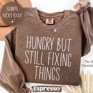 May include: A set of three ceramic nesting bowls in shades of blue, green, and white. The bowls feature a speckled glaze and a simple, modern design. The largest bowl measures approximately 6 inches in diameter.