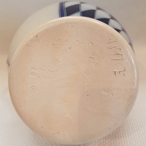 May include: White ceramic vase with a blue and white checkered pattern. The bottom of the vase is marked with the text "Salz glasur" and "Made in Germany".
