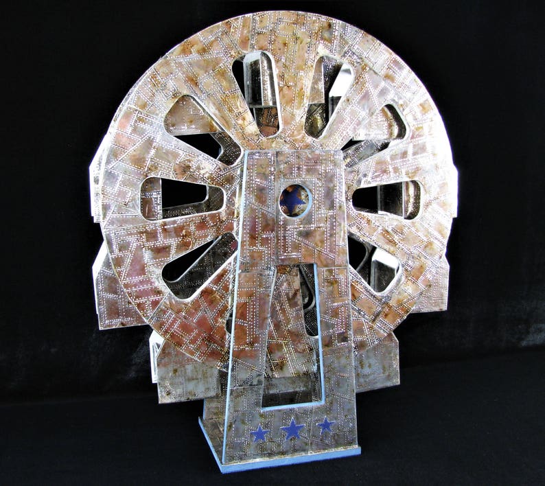 May include: A silver and brown metal model of a Ferris wheel with a blue star design on the base.