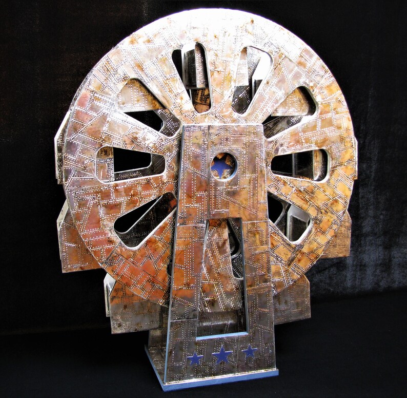May include: A silver and copper-toned metal sculpture of a Ferris wheel with a blue and white star design on the base.