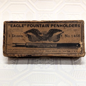 May include: A brown box with the text "EAGLE" FOUNTAIN PENHOLDERS, "1 Dozen", "No. 1456", "EAGLE PENCIL CO., FOUNT PATENTED APRIL 29, SE", and "EAGLE PENCIL, CO., New York, U.S.A."