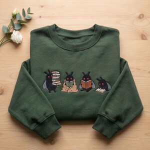Sudadera bordada de Mothman leyendo, sudadera de cuello redondo de Cryptid Bookish, regalo lindo monstruo ratón de biblioteca, ropa Dark Academia, suéter lector