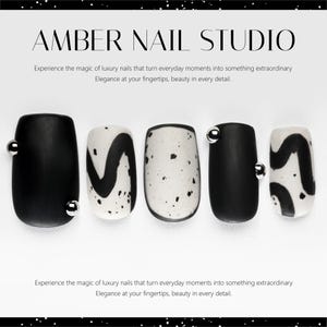 Puede incluir: Un conjunto de cinco uñas postizas. Presentan una mezcla de diseños en negro mate y blanco. Algunas uñas son negras lisas, otras blancas moteadas y otras tienen patrones abstractos negros. Cada uña negra tiene una pequeña cuenta plateada.