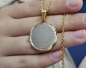 Può includere: Collana con catena dorata e ciondolo rotondo con calligrafia araba in un cerchio argentato. Il ciondolo ha un bordo dorato e una catena dorata.