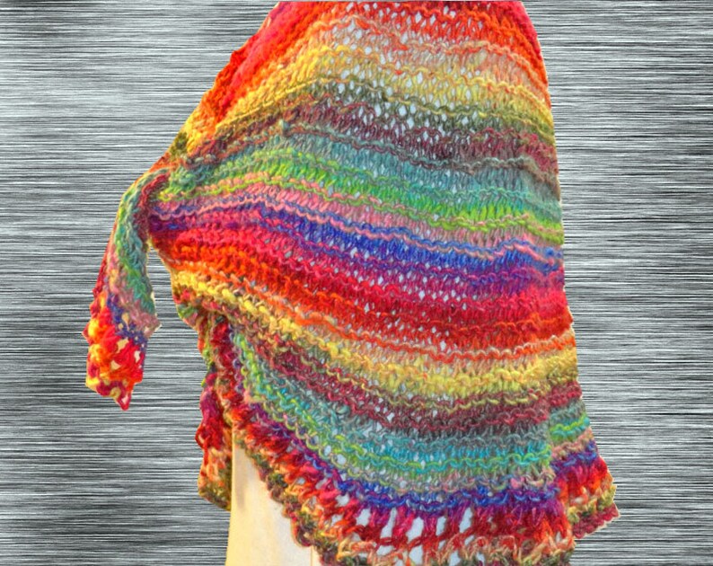 May include: A colorful crocheted shawl with a rainbow pattern. The shawl is made with a variety of yarn colors, including red, orange, yellow, green, blue, indigo, and violet.