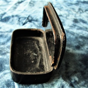 May include: A black wooden box with a hinged lid. The box is open and the inside is empty.