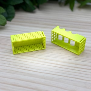 以下が含まれることがあります： グリッドパターンが付いたライムグリーンのプラスチック製収納容器2個。容器は空で、長方形です。