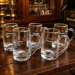 Set of five vintage Heineken beer mugs with gold rim displayed together