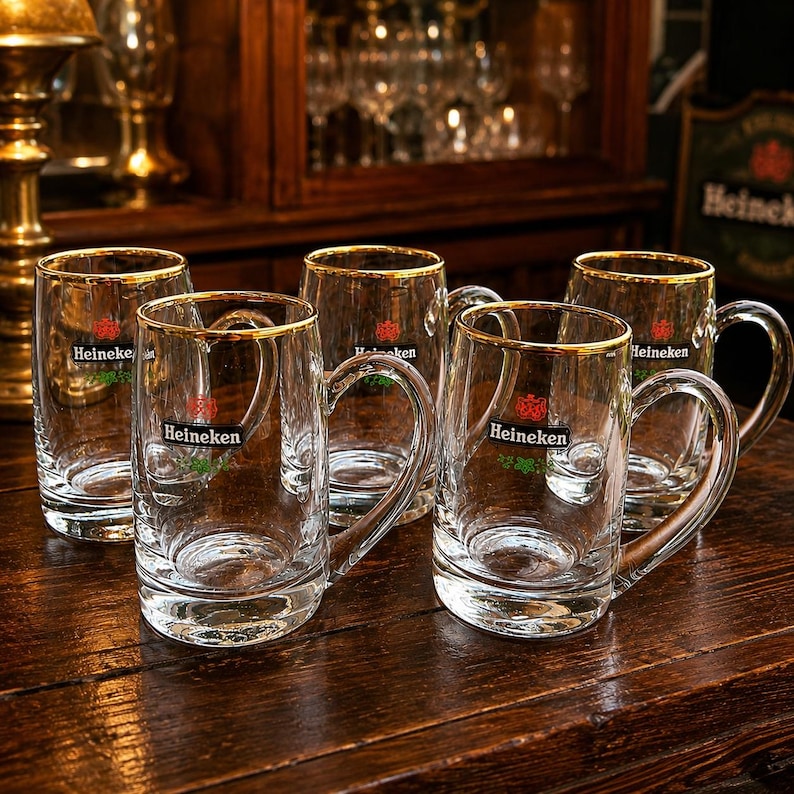 Set of five vintage Heineken beer mugs with gold rim displayed together