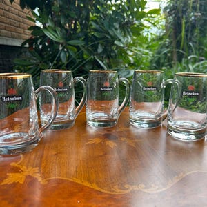 Heavy vintage beer mugs with original Heineken branding and gold trim