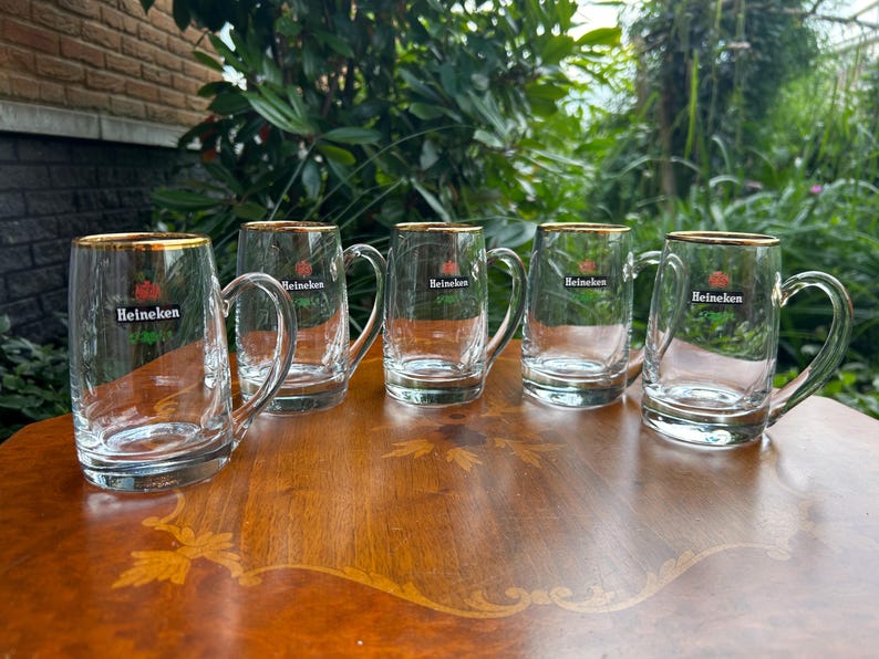 Heavy vintage beer mugs with original Heineken branding and gold trim