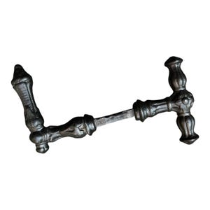 May include: A dark, metallic door handle set featuring an ornate, textured finish with a central square spindle connecting two distinct handle pieces. The design includes decorative, bulbous elements and pointed ends on the handle grips.