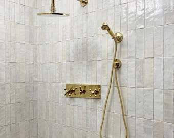 Sistema de chuveiro em latão sem verniz, com ducha plana redonda ajustável e ducha manual.