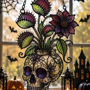May include: A hanging suncatcher featuring a skull-shaped base with intricate filigree patterns in yellow and purple. Emerging from the top are several Venus flytrap plants and a large, dark purple flower, all rendered in a stained glass style.