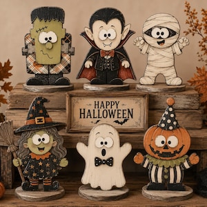 Puede incluir: Un conjunto de seis figuras de Halloween de madera que incluyen un monstruo verde, un vampiro, una momia, una bruja con escoba, un fantasma y un personaje de calabaza, junto a un letrero rectangular de madera con el texto Happy Halloween.