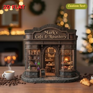 May include: A miniature cafe and roastery model with the text "Mark's Cafe & Roastery" on the sign. The model features a detailed facade with windows, a door, and a small chalkboard sign. A cup of coffee and coffee beans are in the foreground.