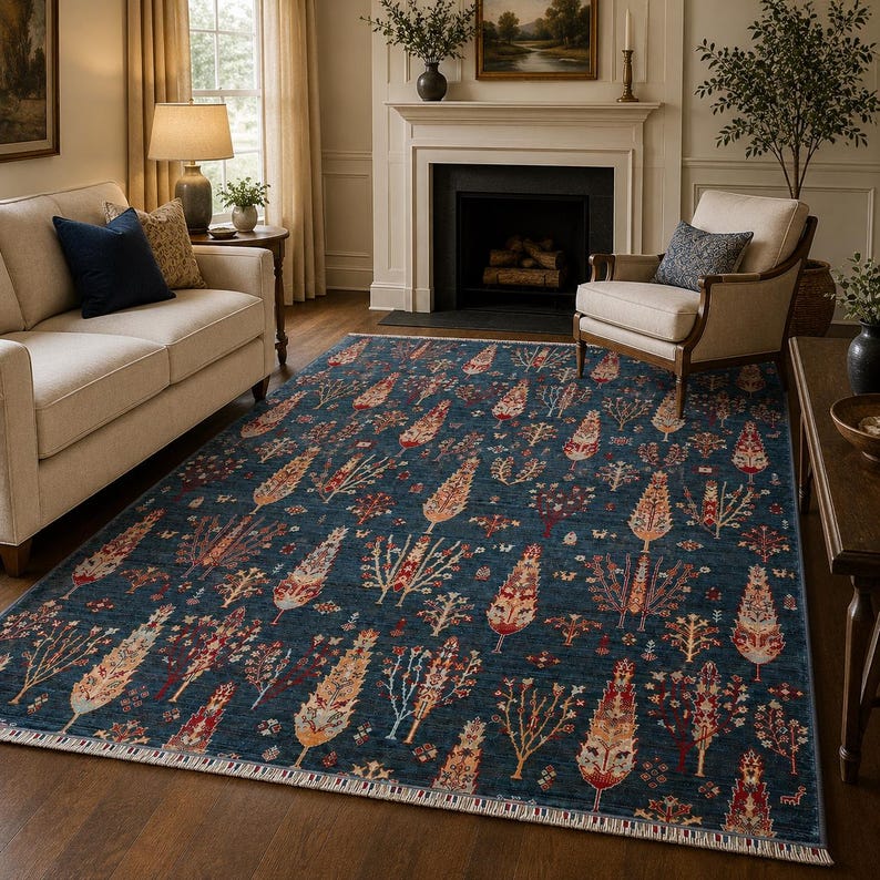 May include: A rectangular area rug featuring a deep blue background with a repeating pattern of stylized trees in shades of red, orange, yellow, and cream. The rug has a short fringe along the edges and a dense, intricate botanical design.