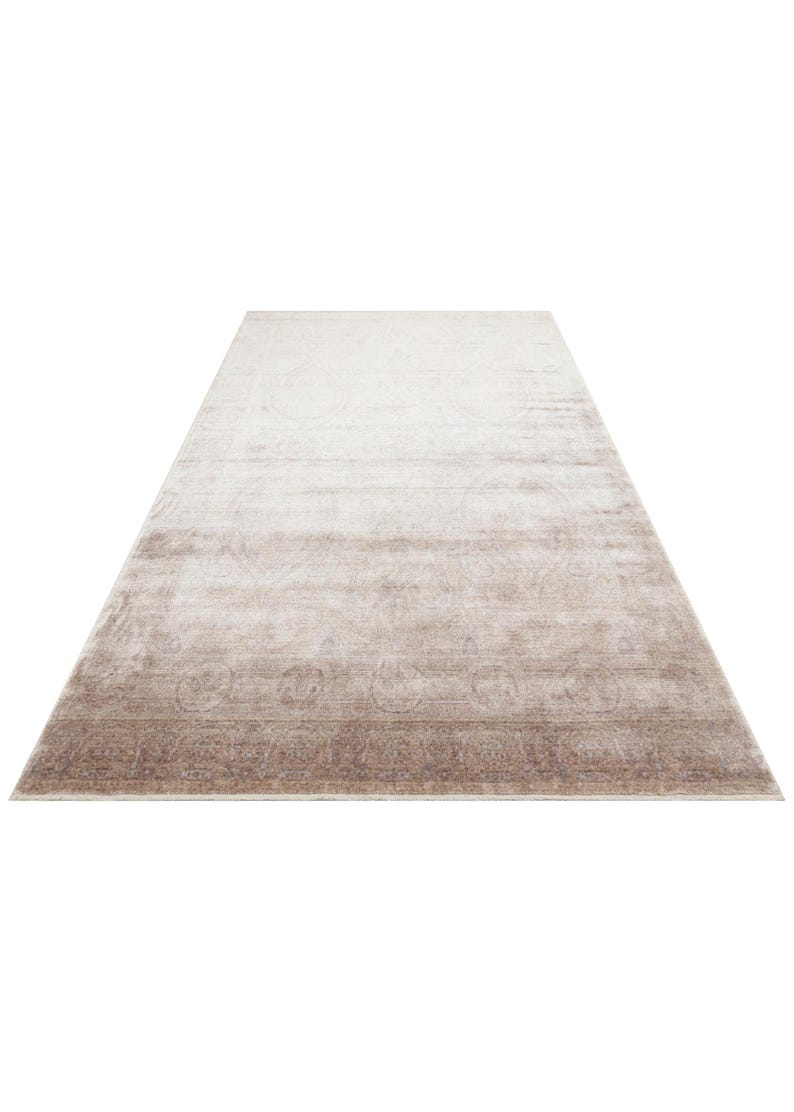 May include: A rectangular area rug featuring a gradient color transition from a light cream at the top to a deep taupe brown at the bottom. The rug displays a faded, intricate medallion and border pattern throughout its surface texture.