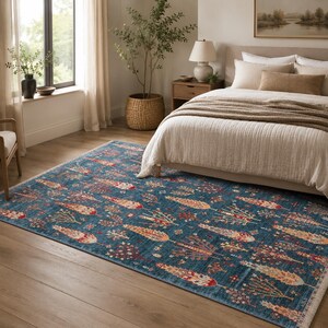 May include: A rectangular area rug featuring a deep blue background with a repeating pattern of stylized trees and floral motifs in shades of orange, red, cream, and brown. The rug has a short fringe along the edges and a flat-woven texture.