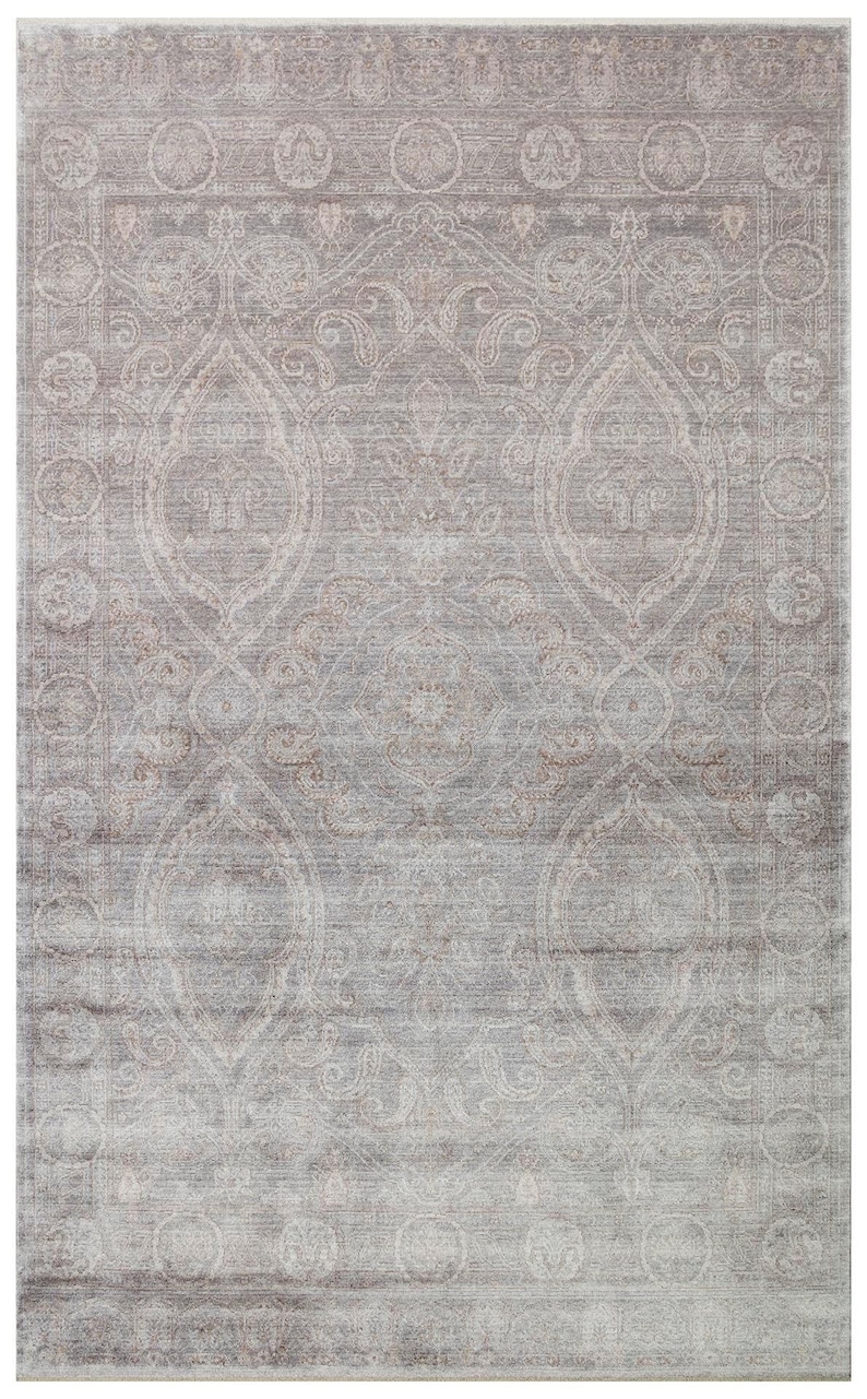 May include: A rectangular area rug featuring a faded, distressed aesthetic in shades of soft gray and muted taupe. The design displays an intricate, symmetrical pattern of ornate medallions and scrolling floral motifs enclosed within a wide border.