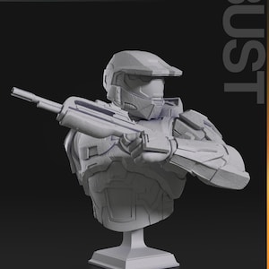 May include: A gray bust of a futuristic soldier holding a rifle. The bust is mounted on a square base. The word "BUST" is printed vertically on the right side of the image. The top left corner of the image has the words "nomnom Figures TURNTABLE".
