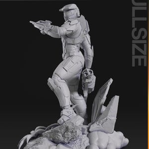 May include: A gray, full-size figurine of a futuristic soldier, holding a weapon and standing on a rocky base. The figurine is detailed with armor plating and a helmet. The words "nomnom Figures TURNTABLE" are in the top left corner.
