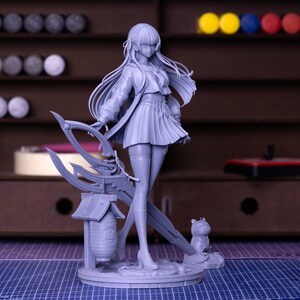 Puede incluir: Una figura gris de un personaje de anime femenino, que lleva una chaqueta, una falda plisada y medias hasta el muslo. La figura sostiene un arma estilizada y se encuentra sobre una base circular con una peque&ntilde;a figura de animal. Una linterna tambi&eacute;n forma parte de la base.