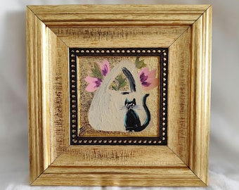 May include: Square framed painting featuring a white handbag with pink flowers and a black cat. The painting has a gold frame with a textured surface. The background is gold with a dark brown border.