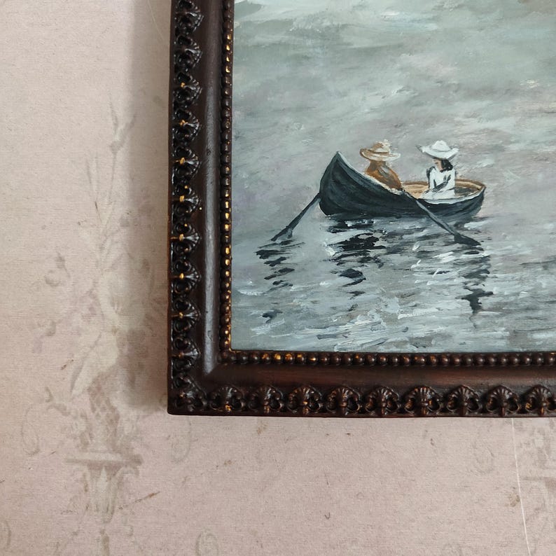 Puede incluir: Una pintura enmarcada de dos personas en un bote de remos en un lago. La pintura est&aacute; realizada en una paleta de grises y azules apagados.